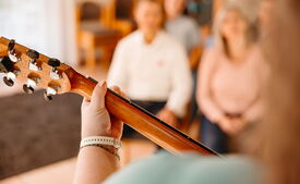 Eine Person spielt Gitarre während des Worships im Gottesdienst der Heilsarmee Affoltern am Albis.